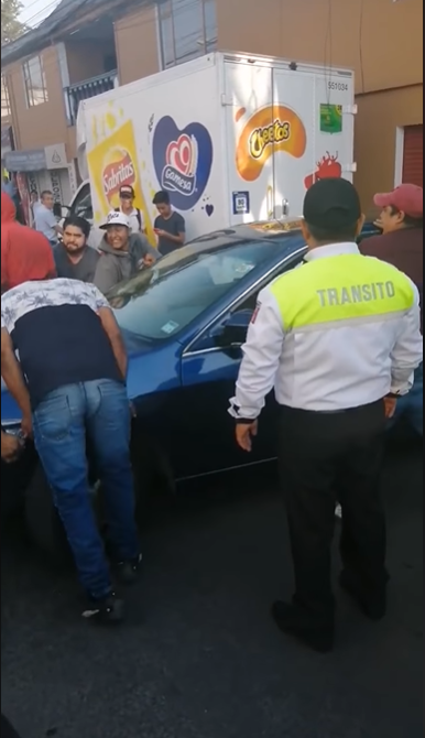 Mujer se estaciona a media calle y conductores cargan su auto para orillarla