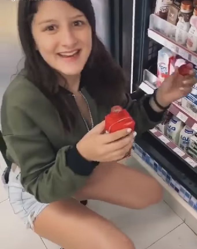 Joven prueba leche y la regresa al refigerador de una tienda