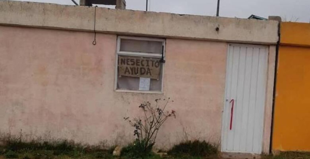 Familia enferma de COVID-19 pide ayuda con letreros en la ventana