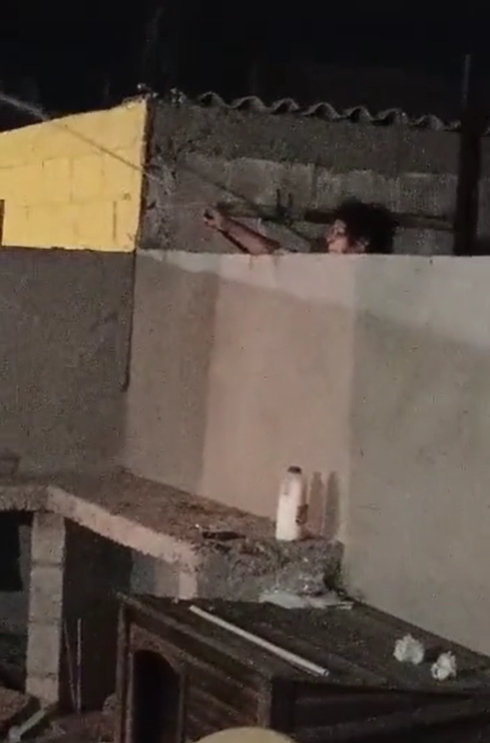 Mujer moja con una manguera a vecinos que organizaron fiesta